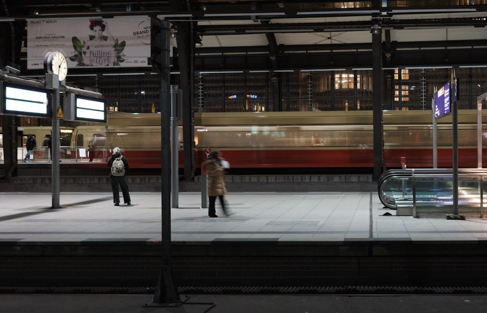 a couple of people standing on a train platform