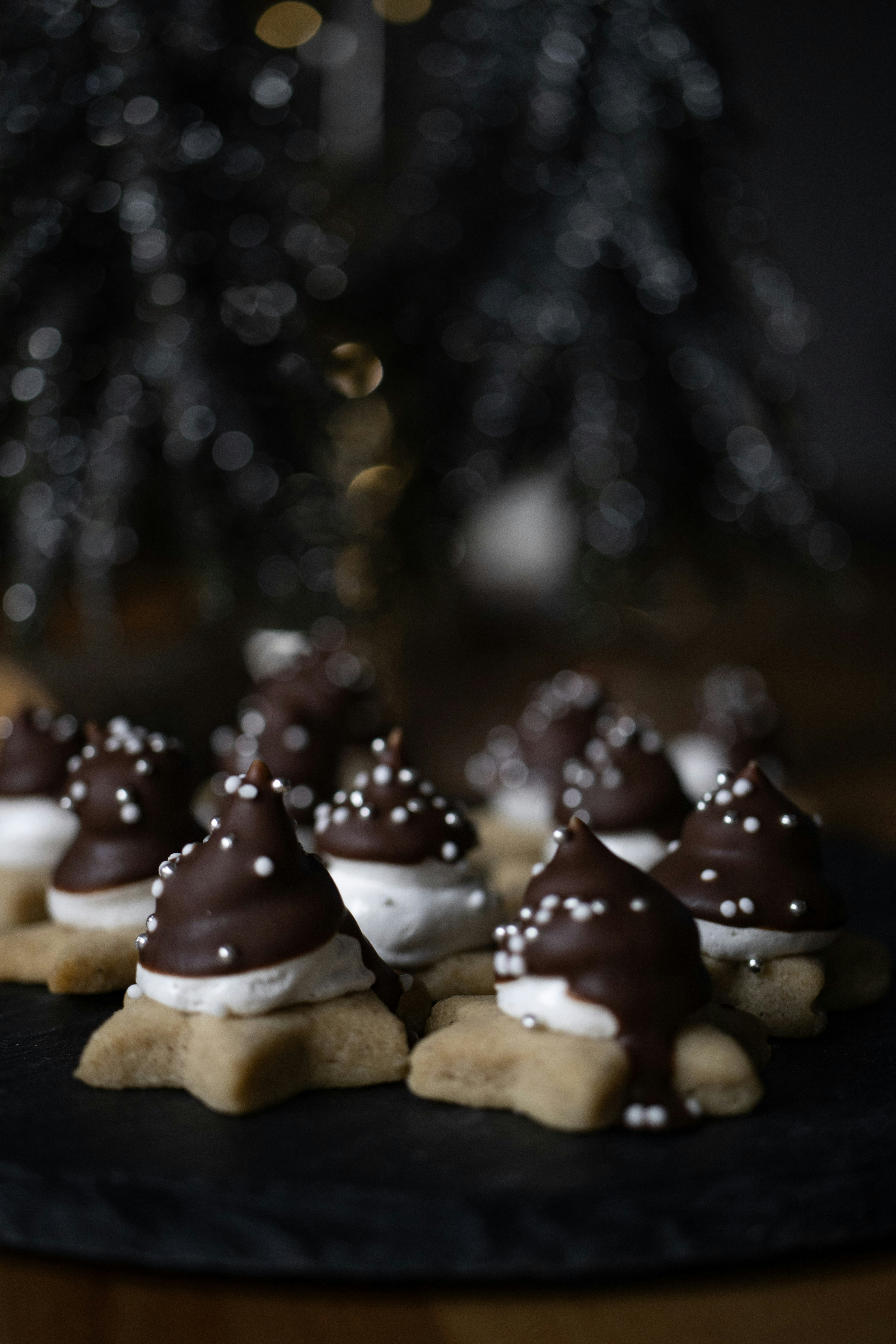 a black plate topped with cookies covered in chocolate