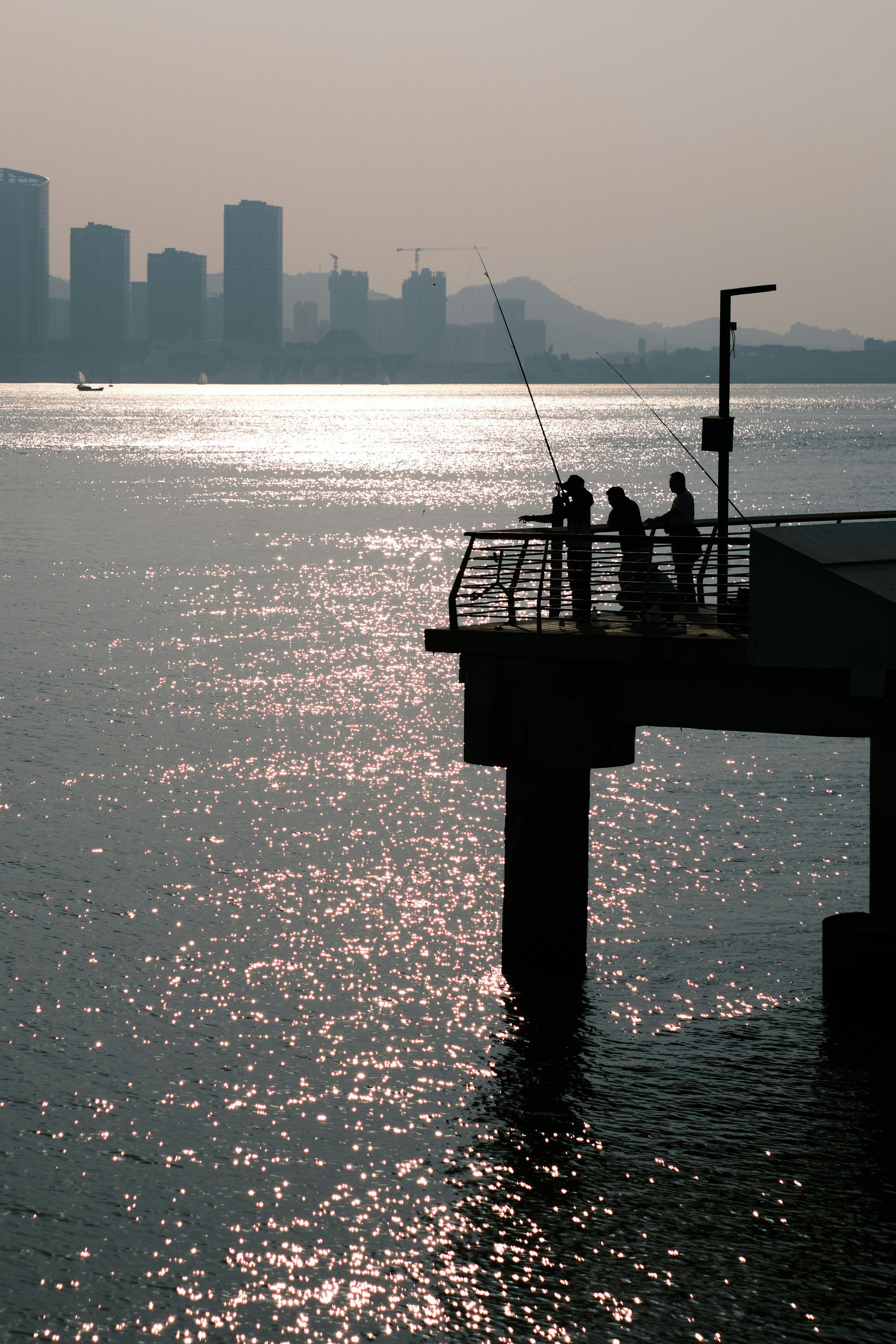 a group of people fishing off of a pier