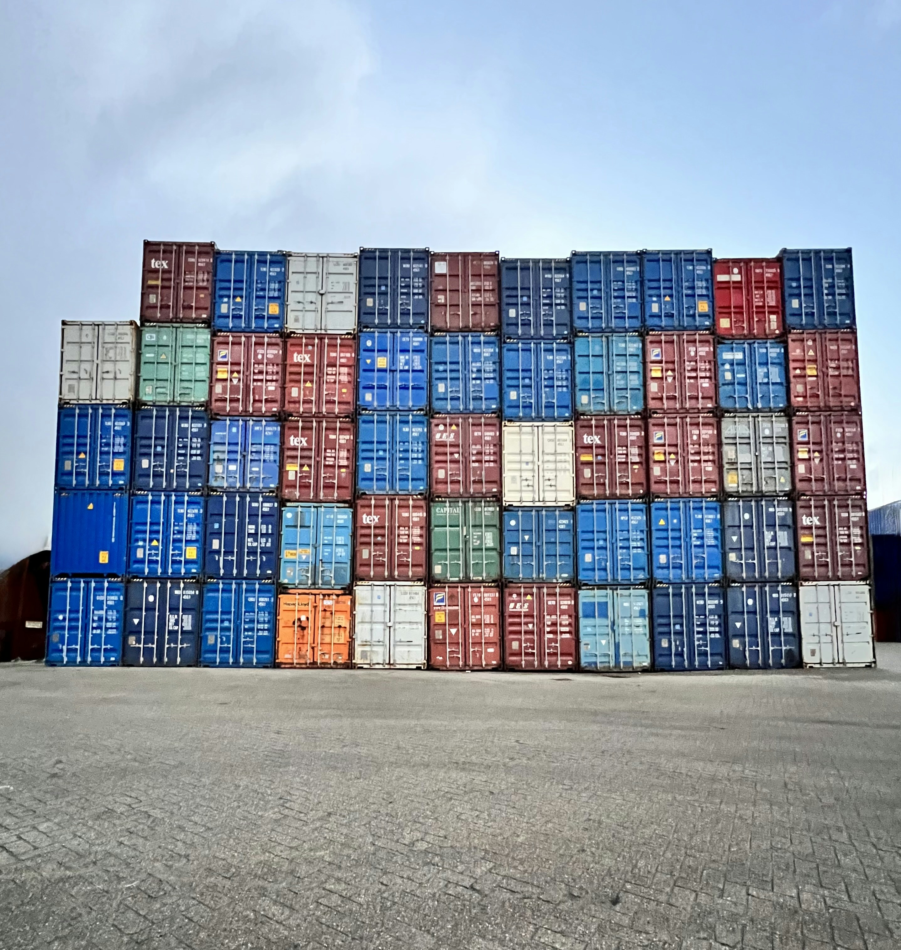 ein großer Stapel von Containern, die auf einem Zementboden sitzen