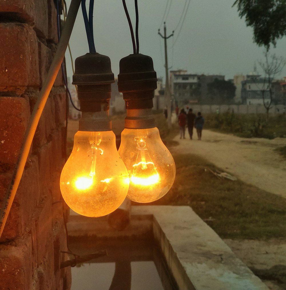 a couple of light bulbs hanging from a brick wall