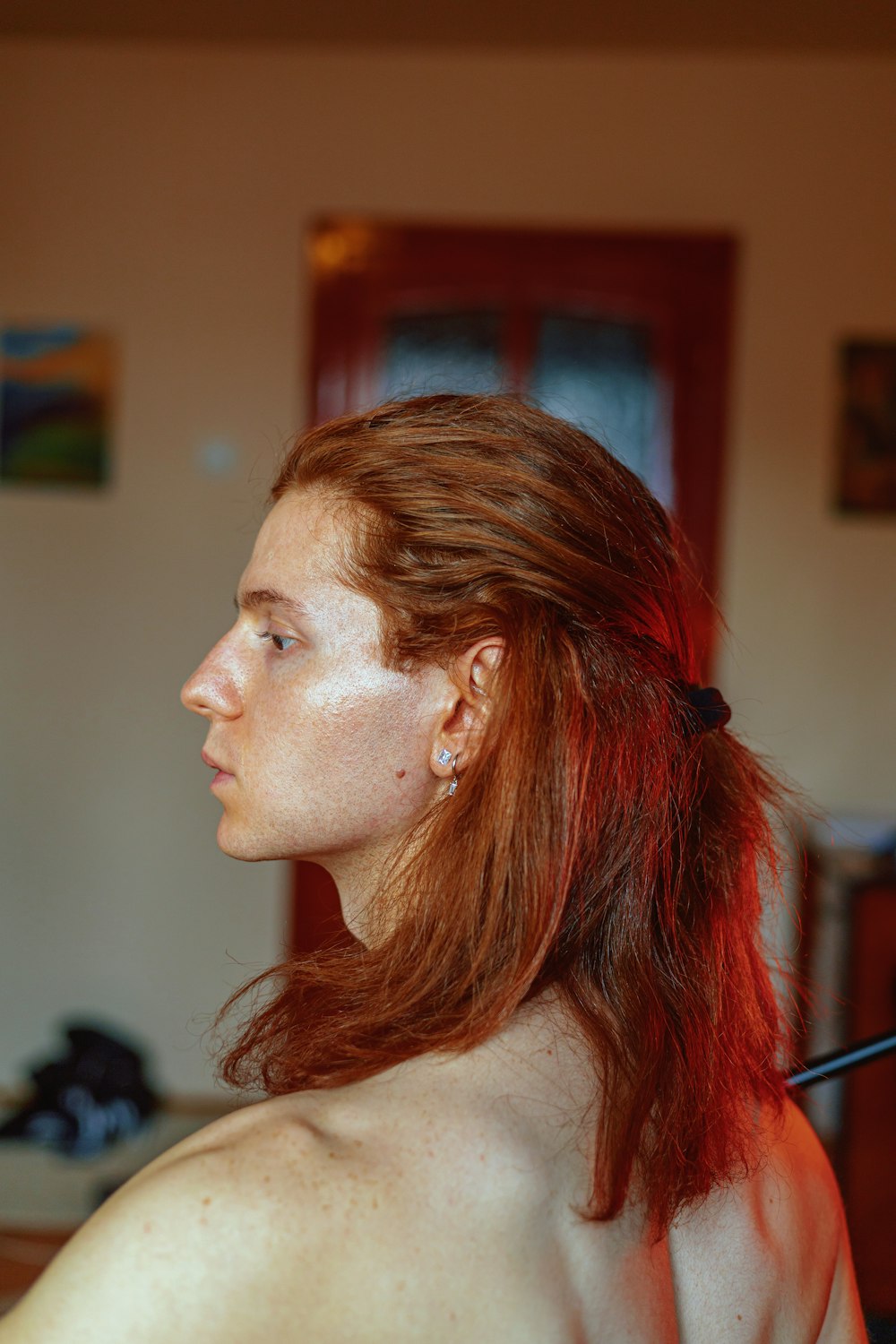 a woman with red hair is looking off into the distance