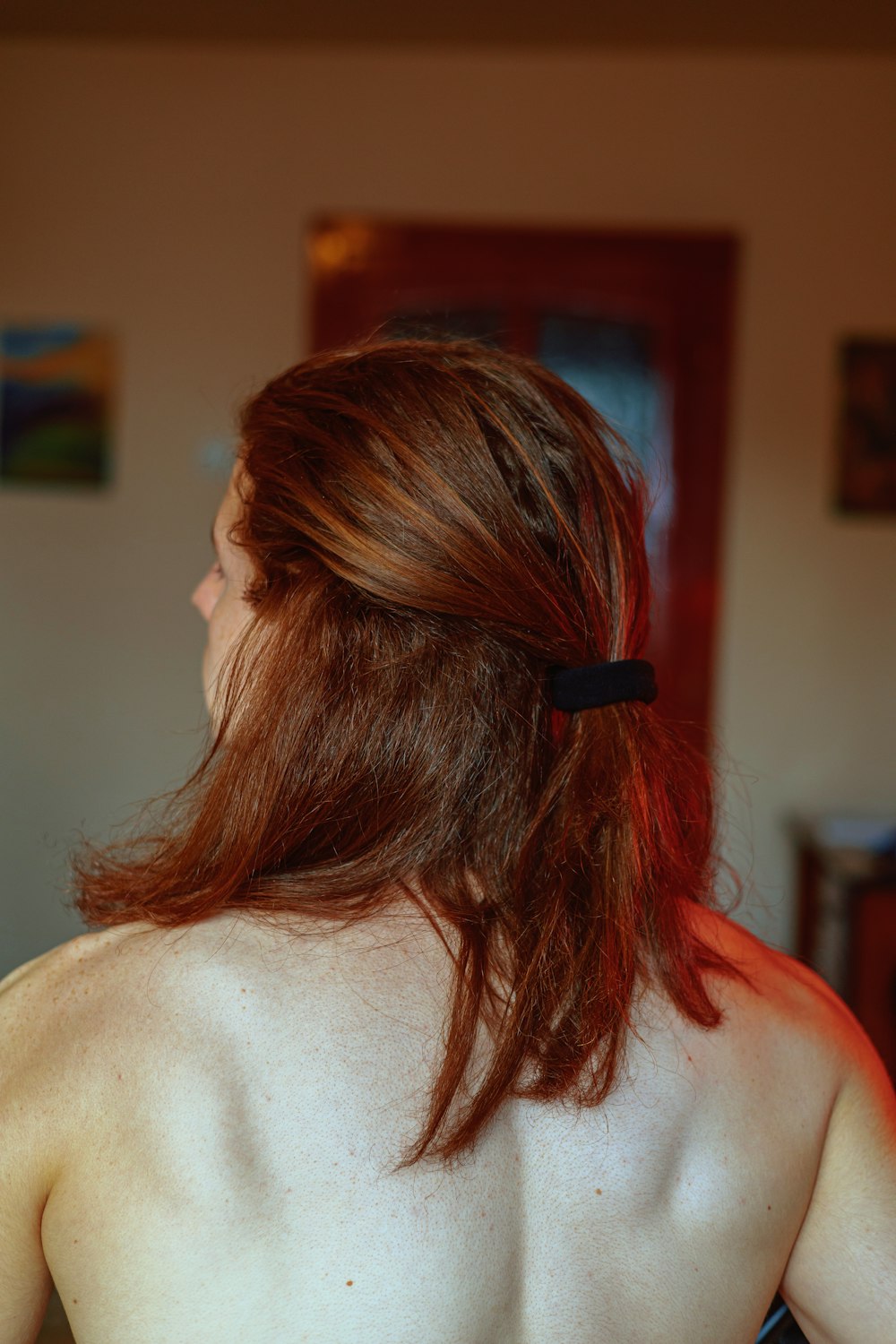 a woman with long red hair wearing a black tie