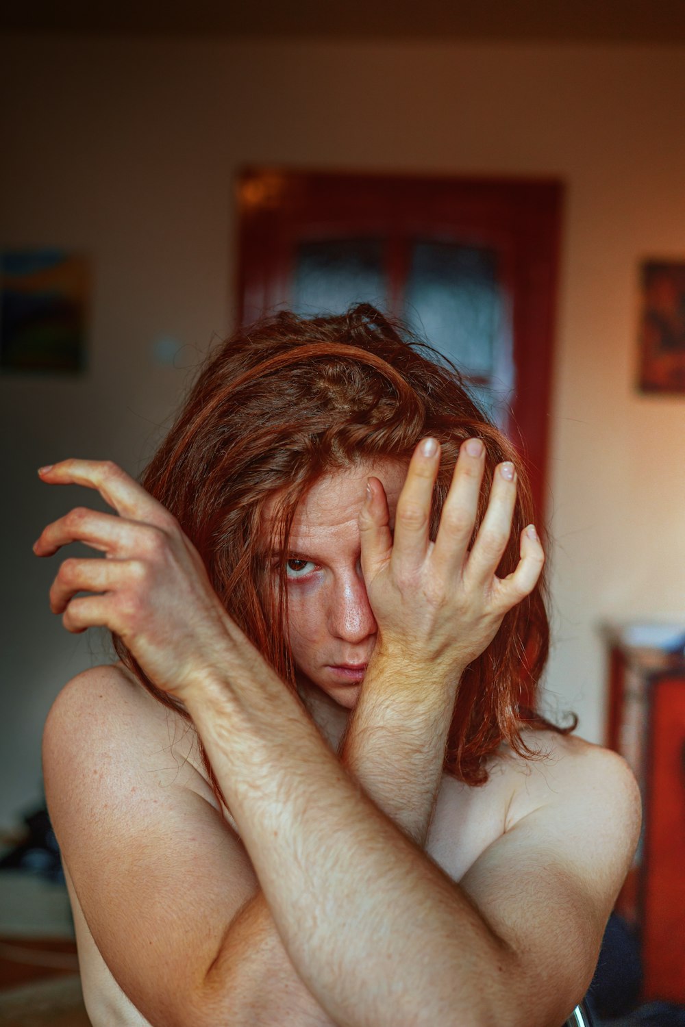 a woman with red hair covering her face