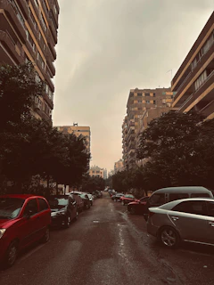 A crowded Chicago street with dense apartment buildings and a few parked cars squeezed between them.