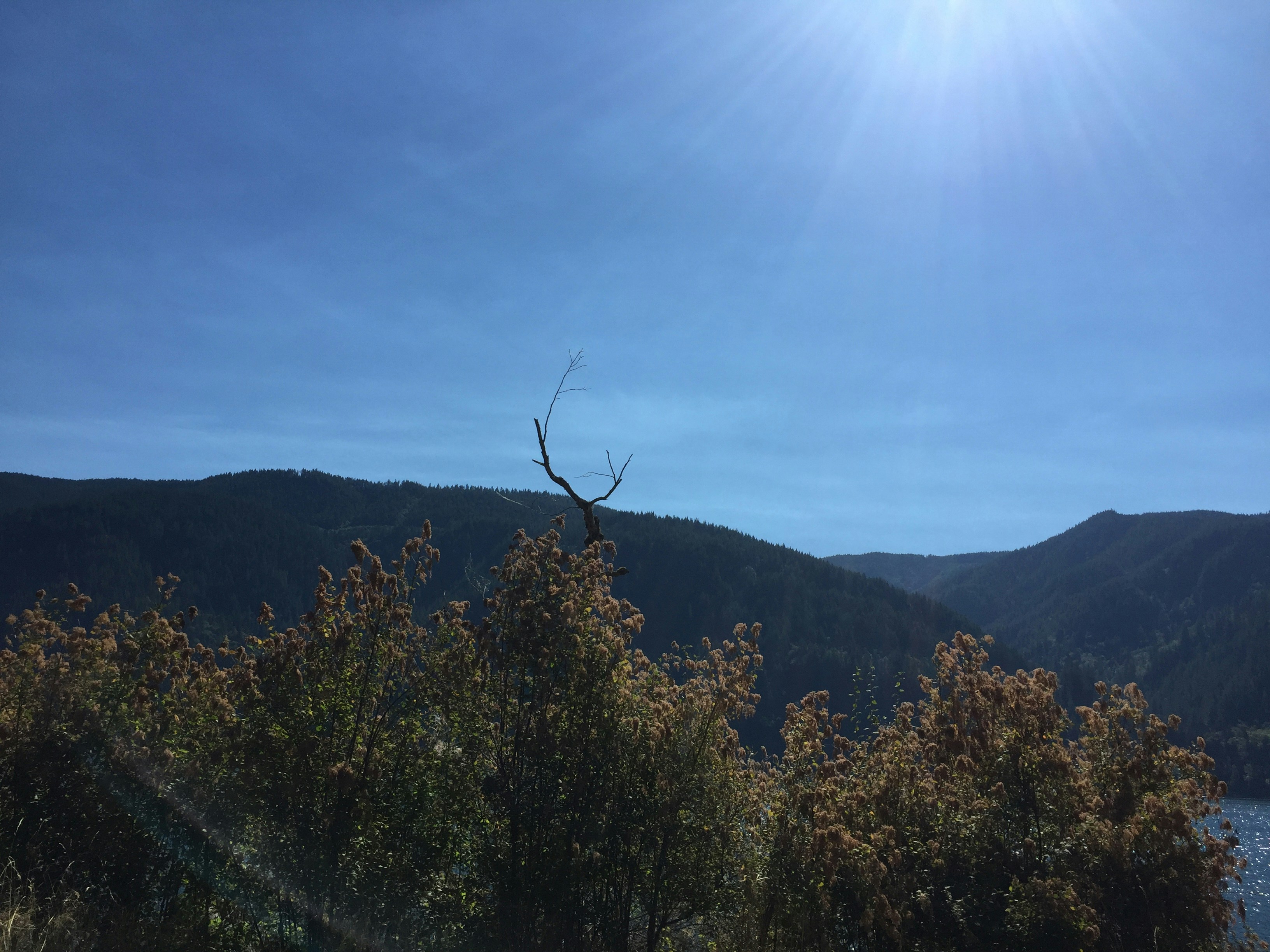 the sun shines brightly over a mountain range