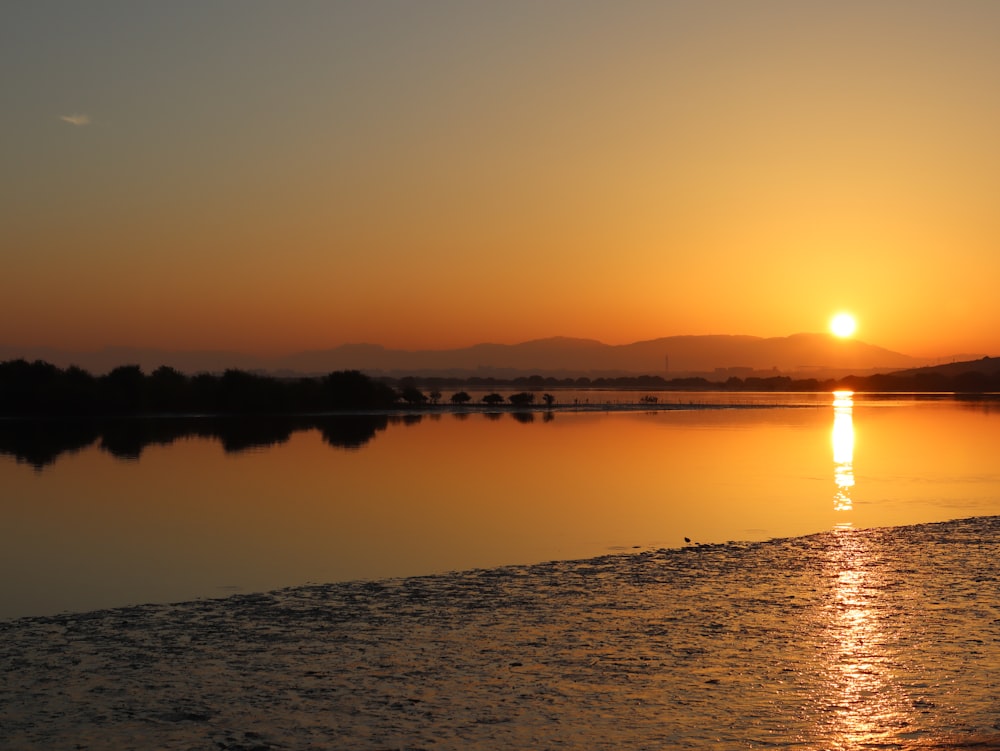 the sun is setting over a body of water