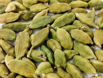 a pile of green seeds on a white surface