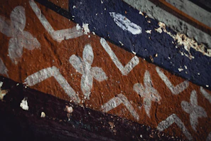 Close-up of a detailed wall mural painted with warm earth tones and intricate patterns.