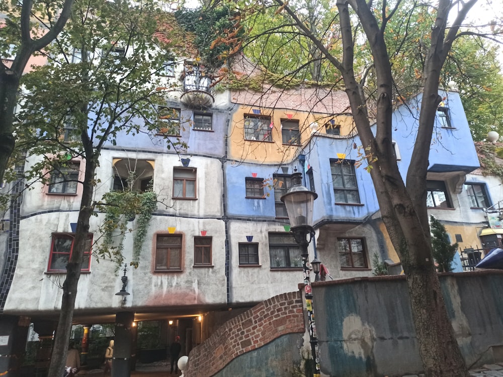 a tall building with lots of windows next to a tree