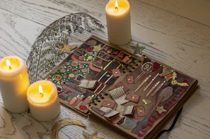 A rustic wooden table with candles, crystals, and an open ancient-looking book of spells.