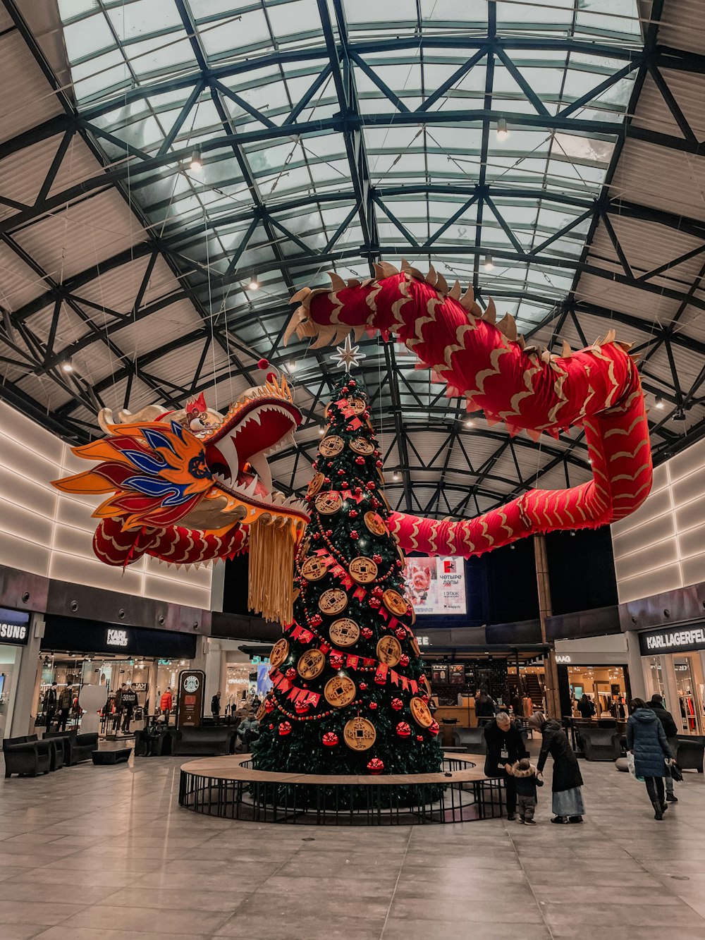 a christmas tree with a dragon decoration in a building