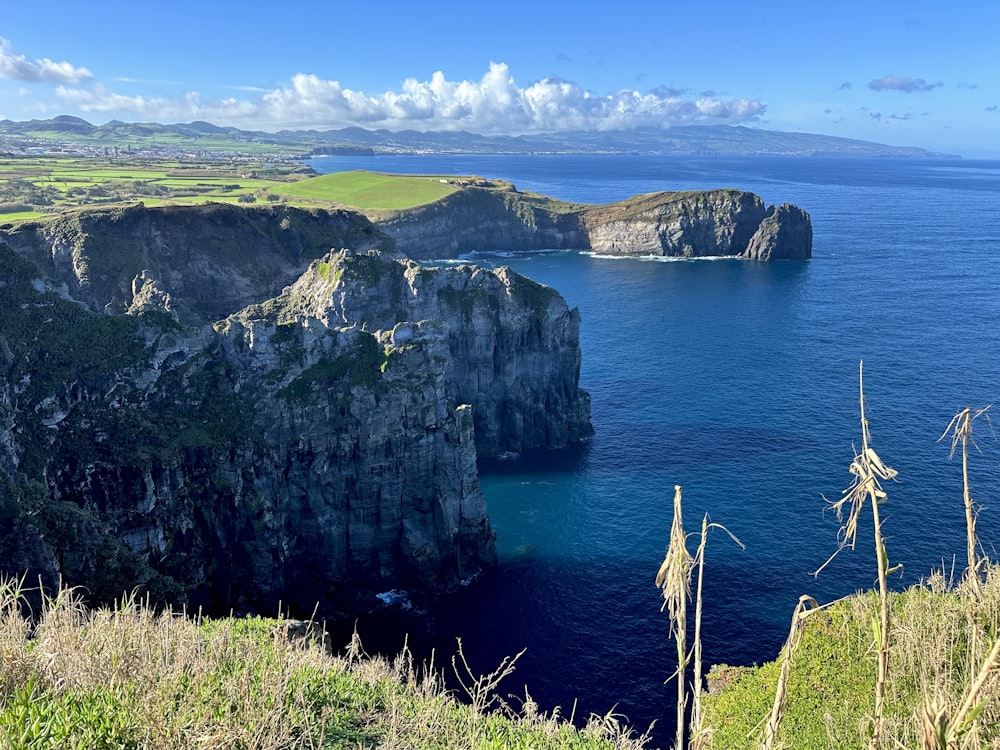 a large body of water surrounded by a lush green hillside