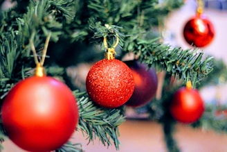 Close-up of handcrafted Christmas baubles hanging on a beautifully decorated tree.
