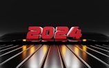 A futuristic display of the number 2024 in bold red characters set against a sleek, reflective black and metallic backdrop. Yellow and orange lights illuminate the background.