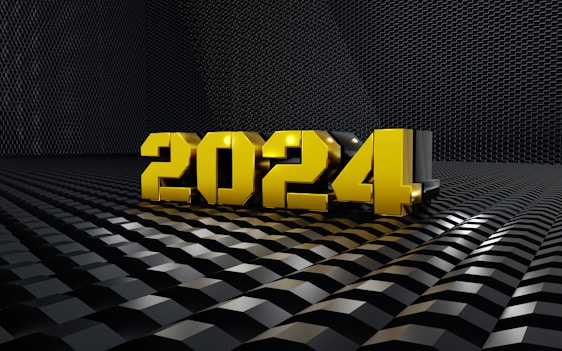 Golden 3D numbers forming '2024' placed on a reflective, textured black surface with a geometric pattern, giving a futuristic and sleek appearance.