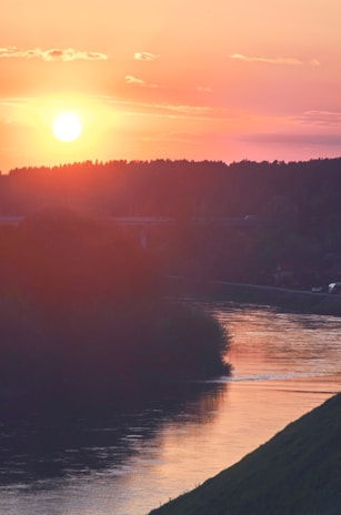 A sunset view over a tranquil river, symbolizing growth and stability.