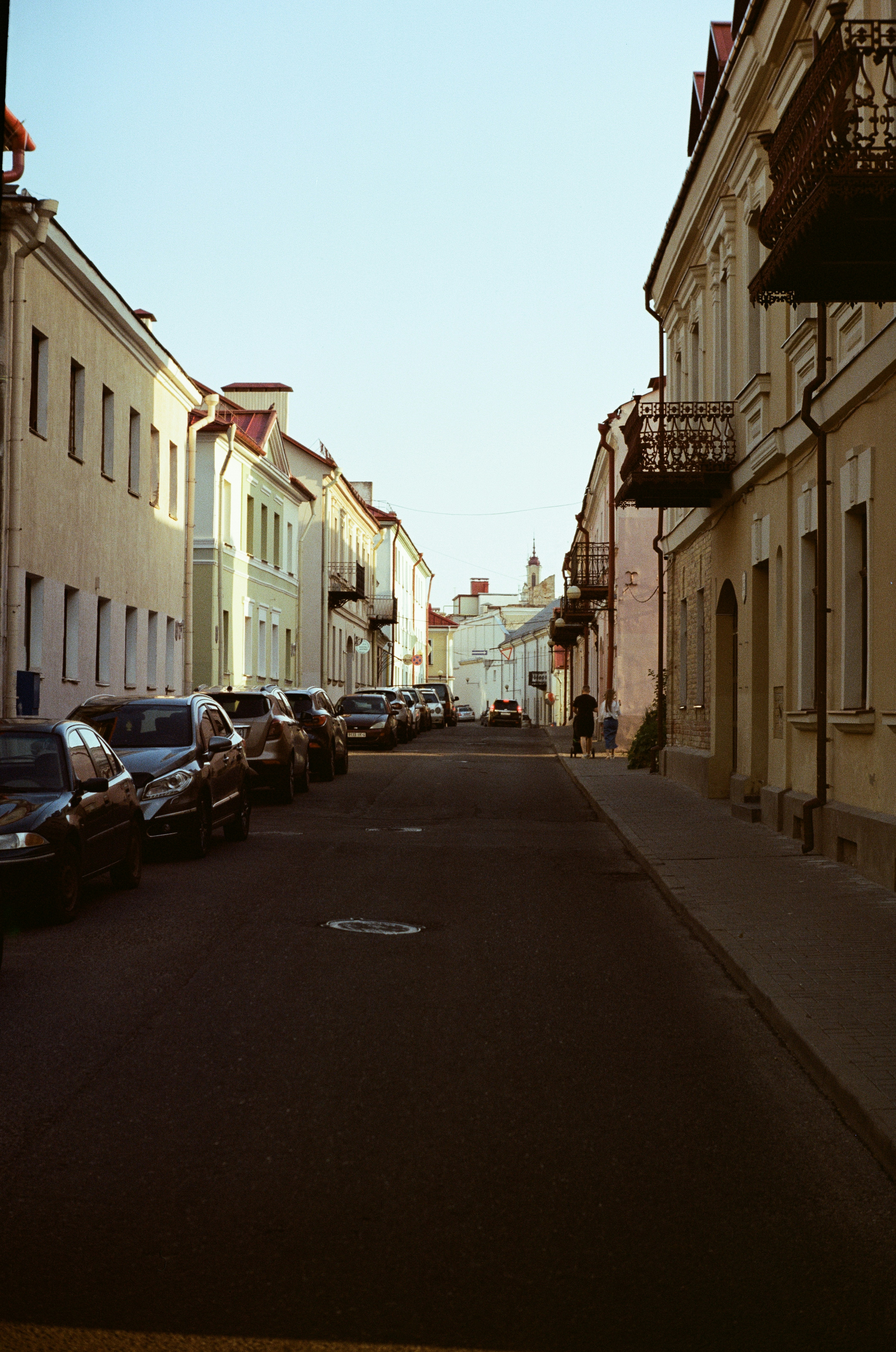 a street lined with parked cars next to tall buildings