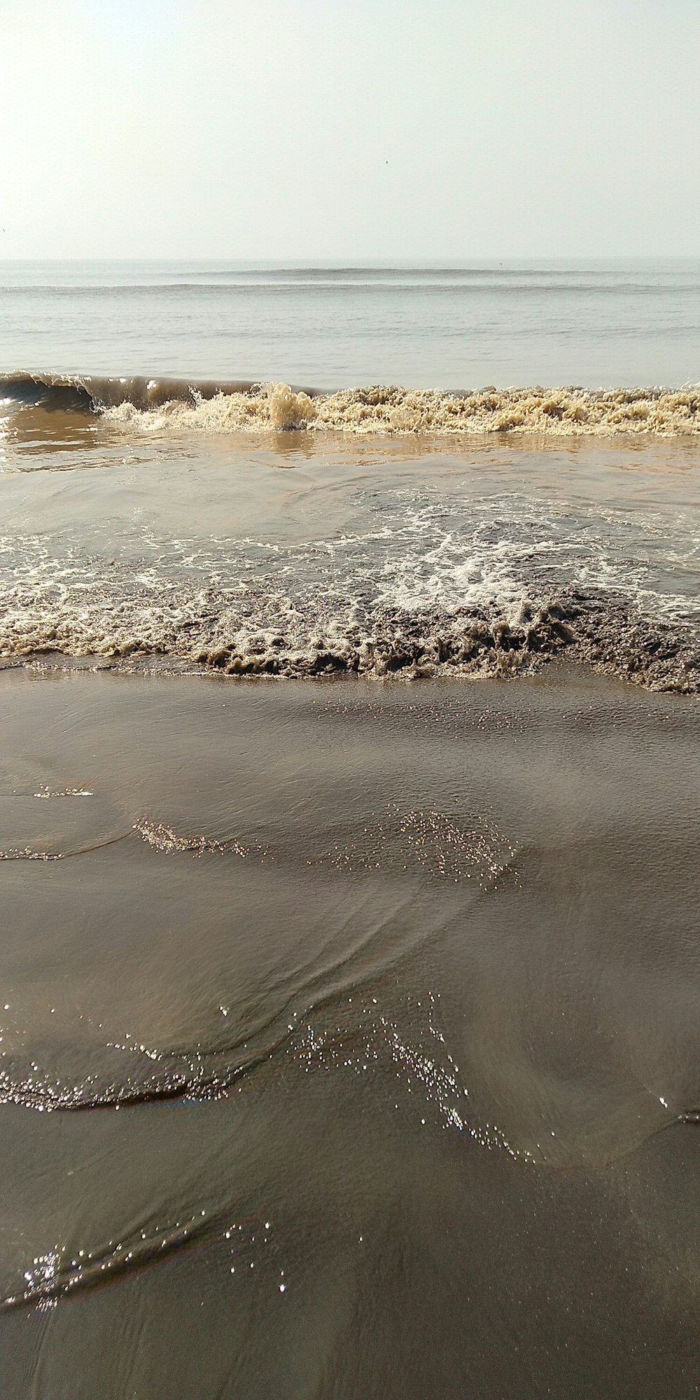 a person riding a surfboard on top of a wave covered beach