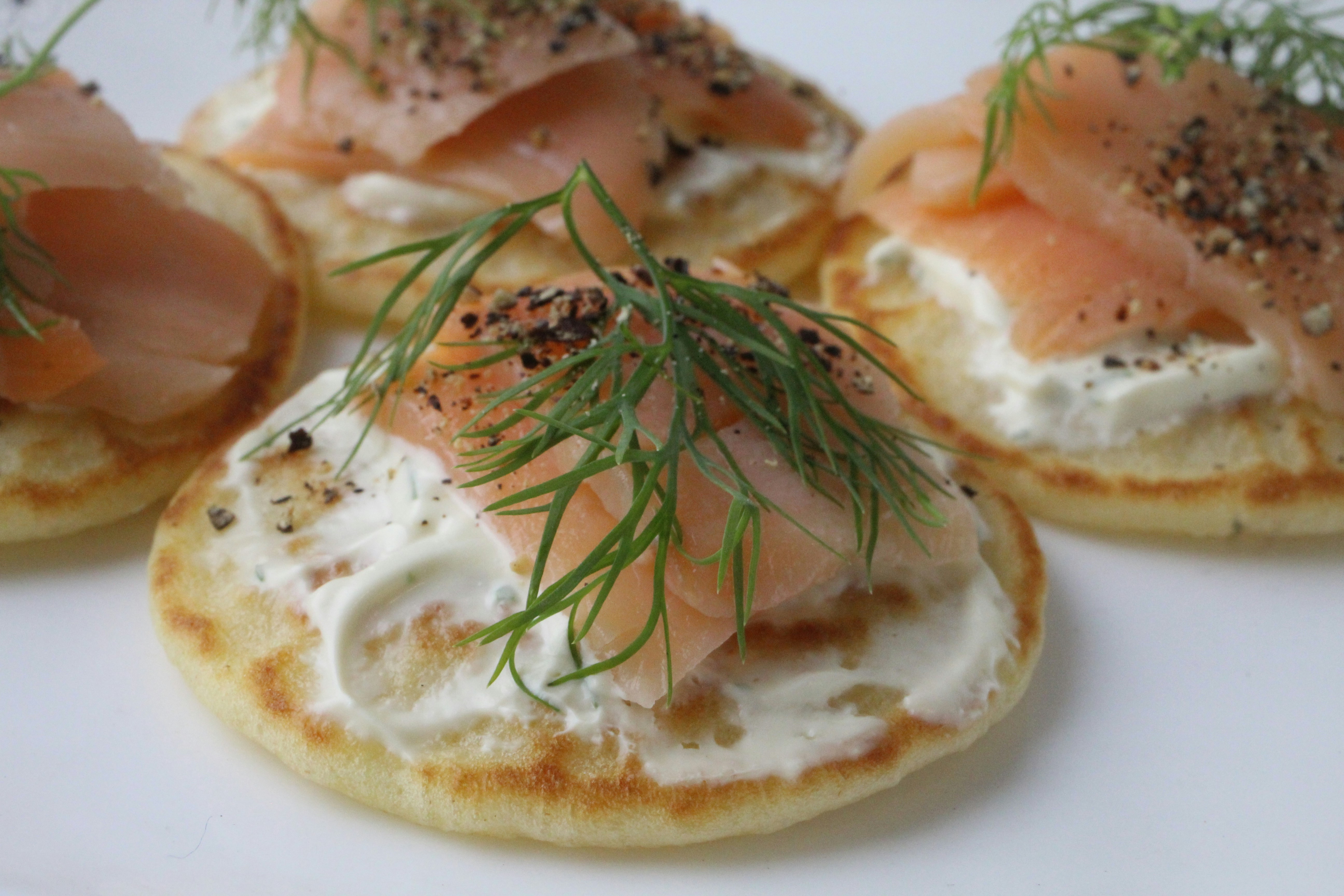 A crisp rice cake topped with light cream cheese, smoked salmon, and fresh dill
