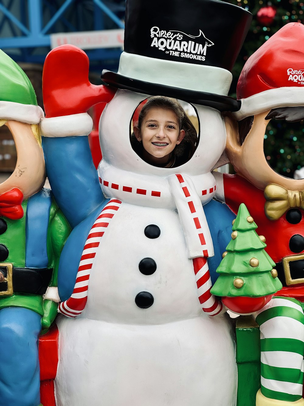 a woman in a santa hat and a snowman statue