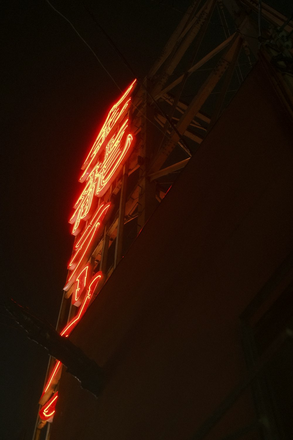 a red neon sign hanging from the side of a building