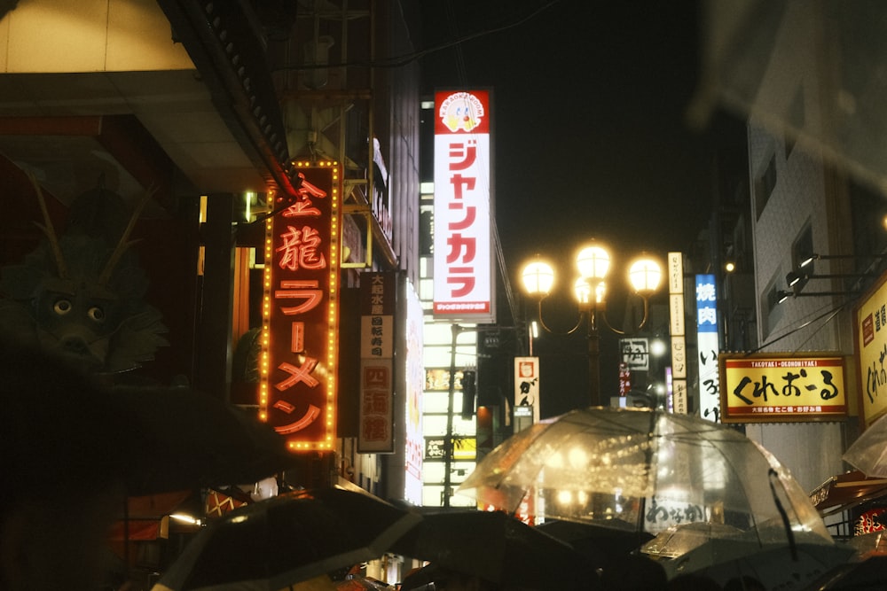 a busy city street at night with lots of neon signs