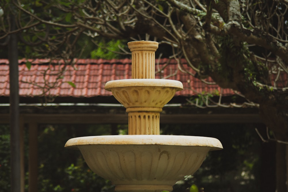 a stone fountain with a red roof in the background