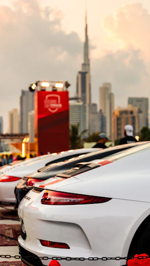 A dynamic montage of a red sports car, a shiny vintage classic, and a modern electric vehicle set against a city backdrop.
