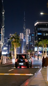Mehak Plumbing van parked outside a downtown Dubai high-rise at sunset.