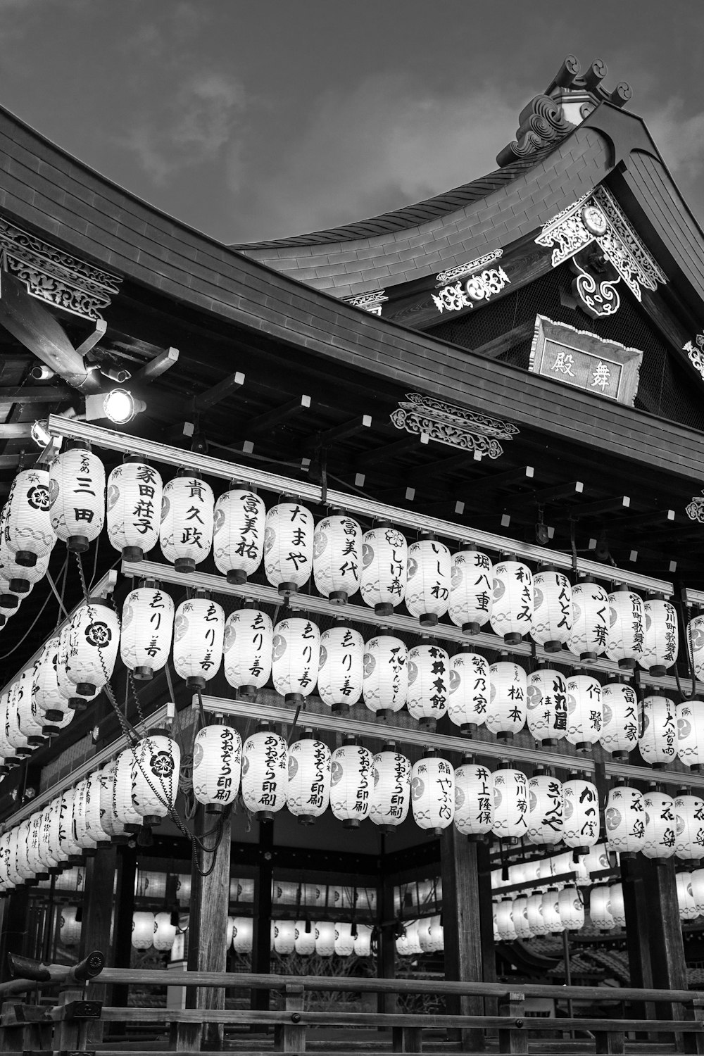 a black and white photo of a building with lanterns