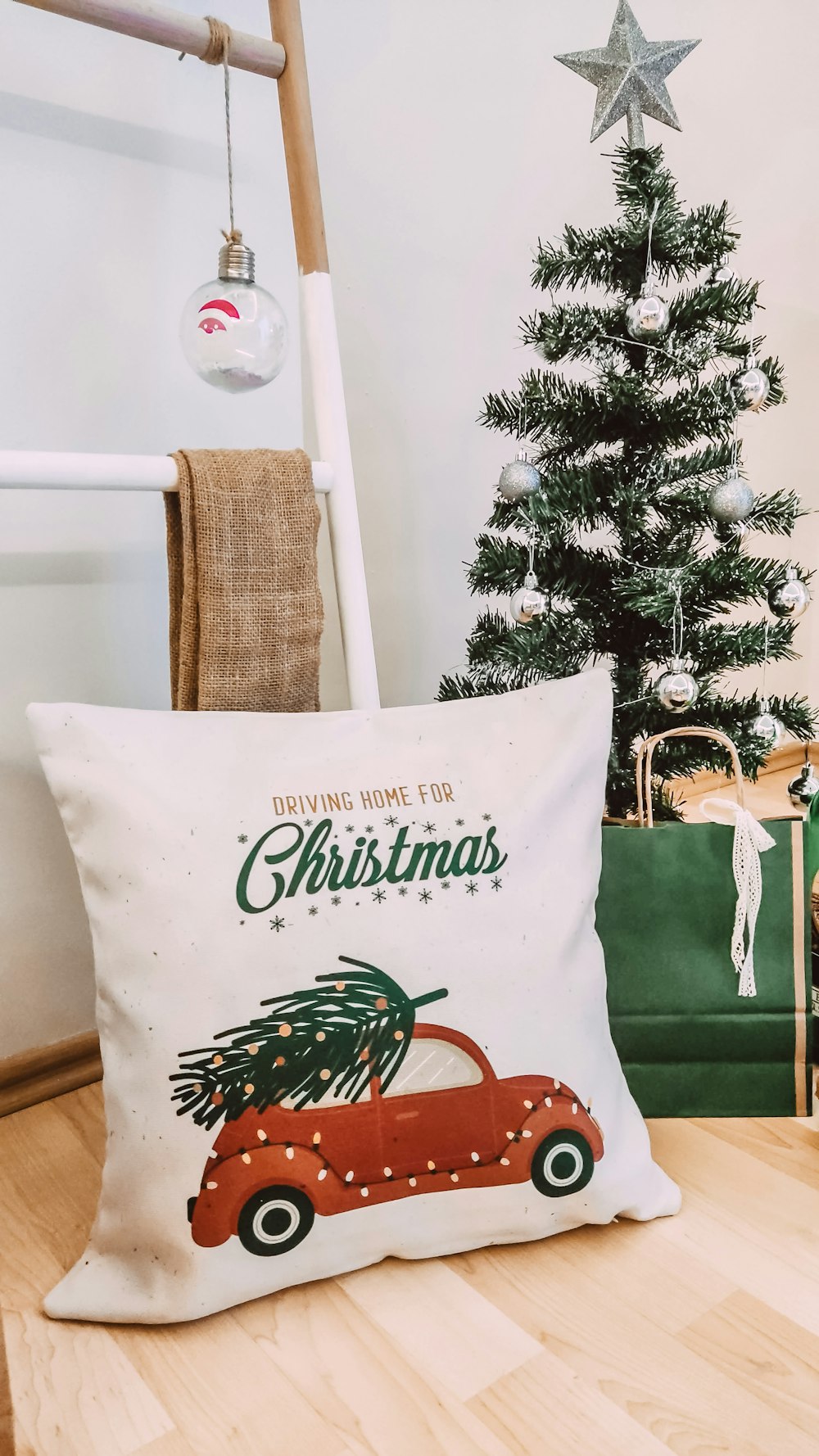 a christmas pillow sitting on top of a wooden floor