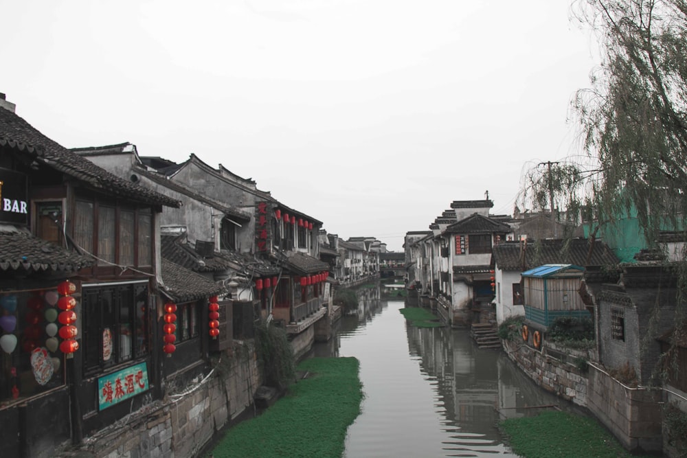 a river running through a small village next to tall buildings