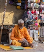 a man sitting on the ground in front of a store