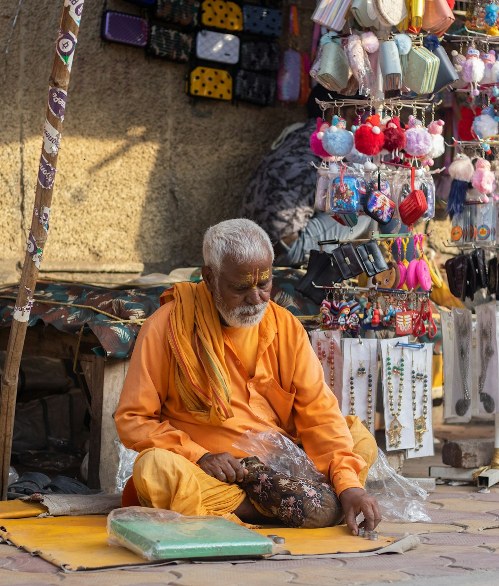 a man sitting on the ground in front of a store