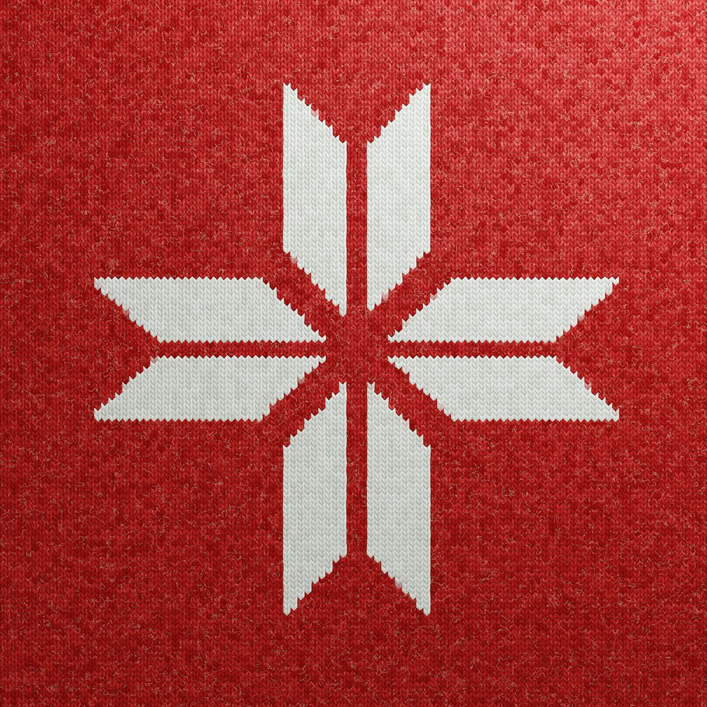 a cross stitch pattern of a white flower on a red background