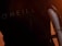 Close-up of a section of a wetsuit with the word 'O'NEILL' visible, and part of a surfboard with an orange light illuminating the scene, suggesting sunset or sunrise.