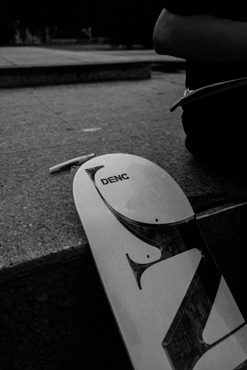 a skateboard laying on the ground next to a person