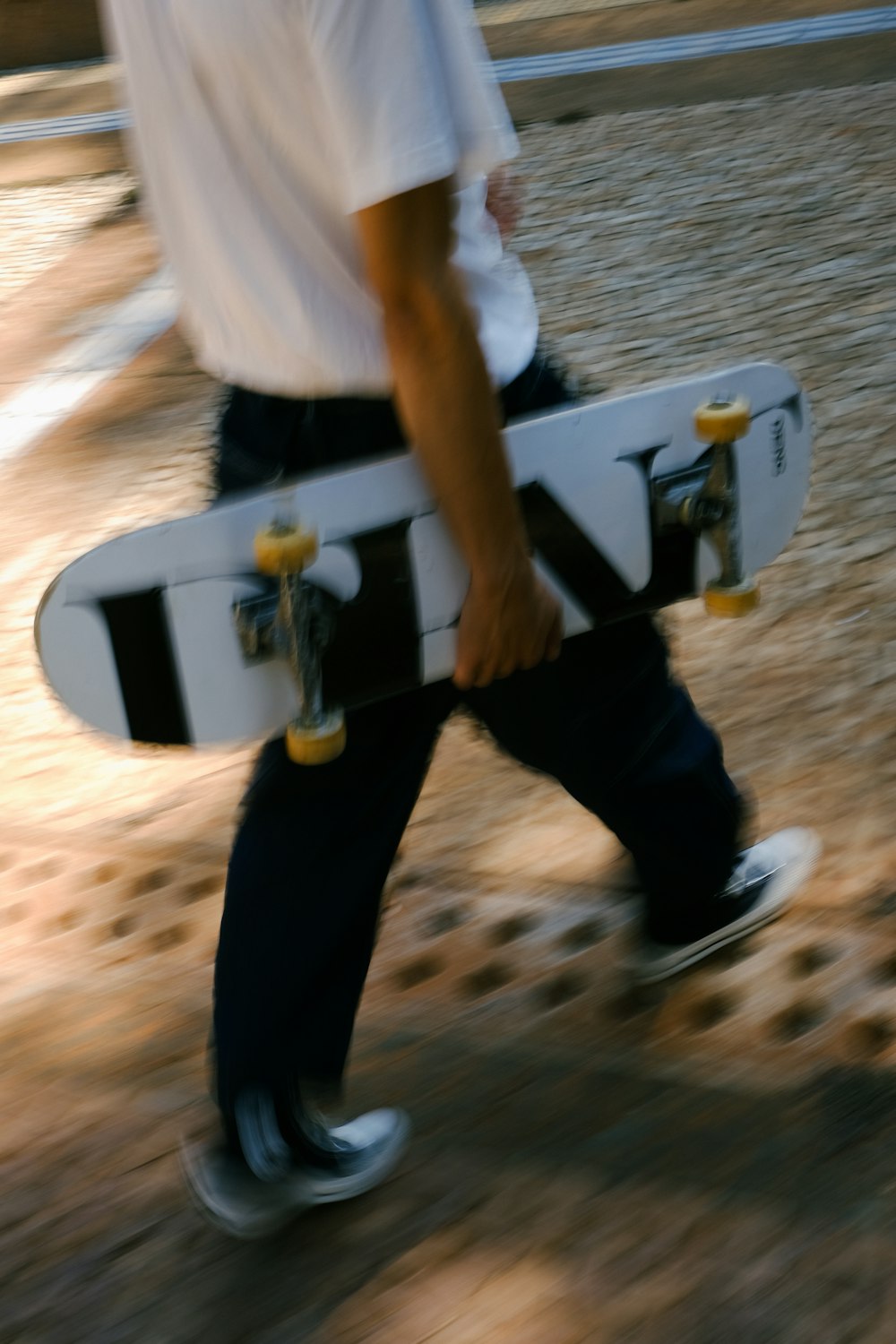 a man walking down a street holding a skateboard