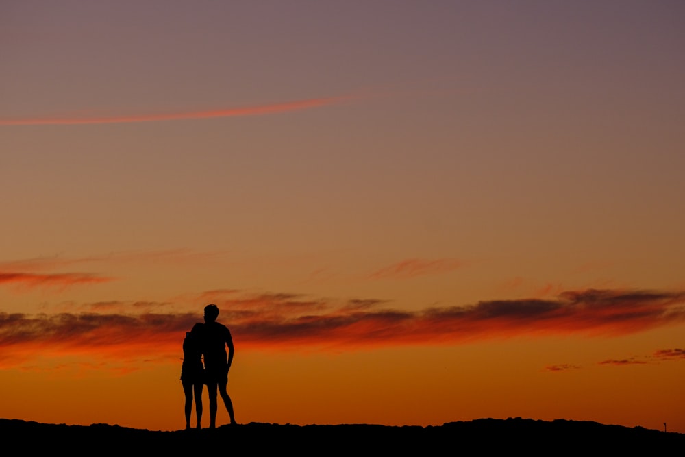 a couple of people standing on top of a hill