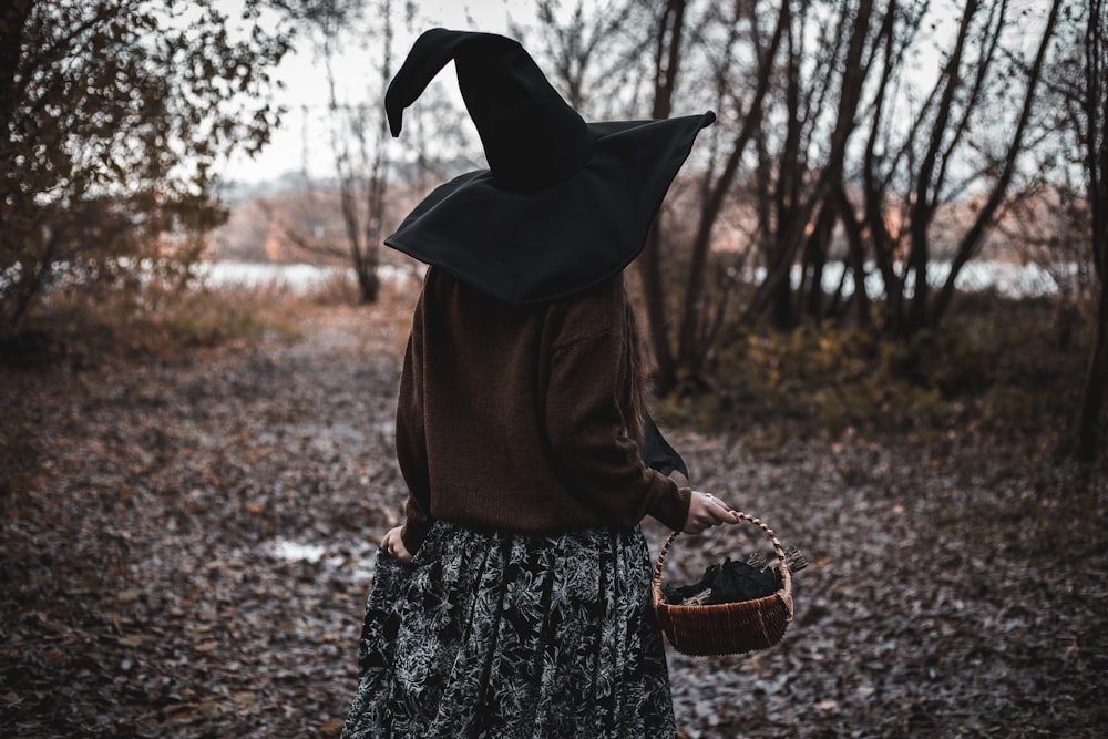a woman wearing a witches hat and holding a basket