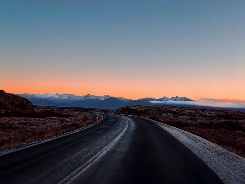 a long road with mountains in the background