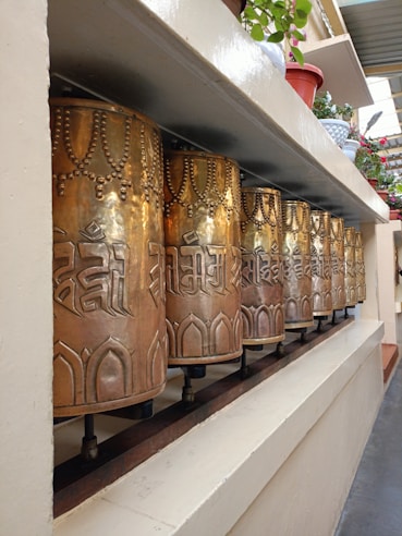 a row of metal bells sitting on top of a shelf