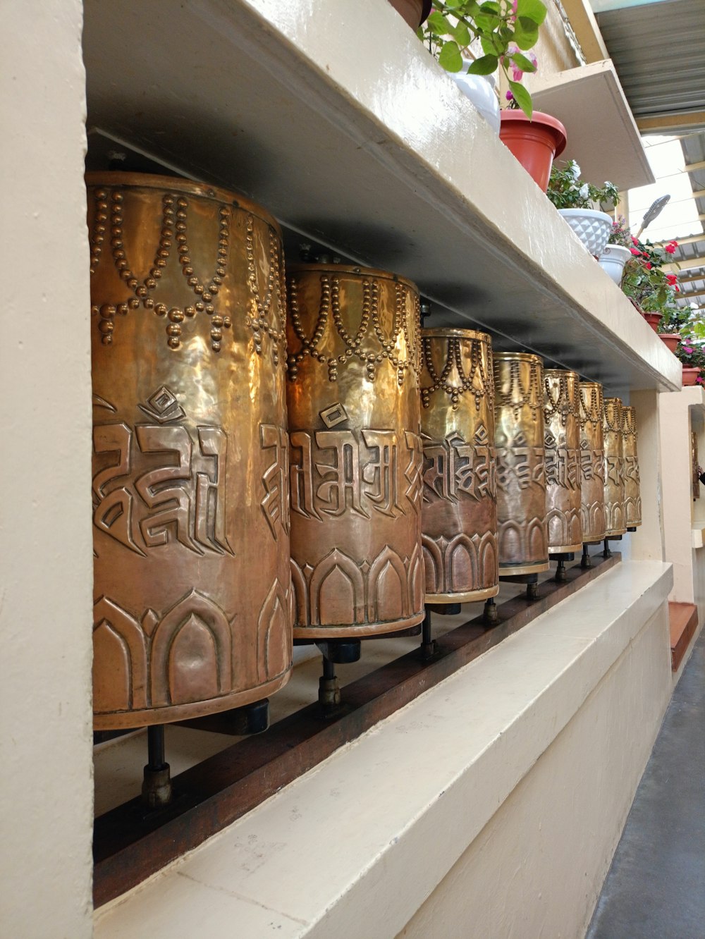 una hilera de campanas de metal colocadas encima de un estante