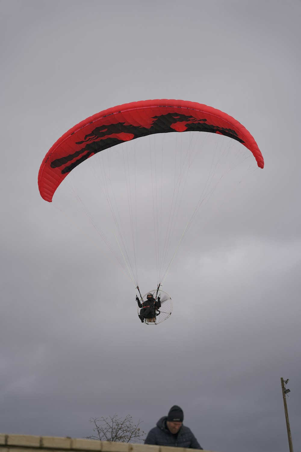a man is parasailing in the air on a cloudy day