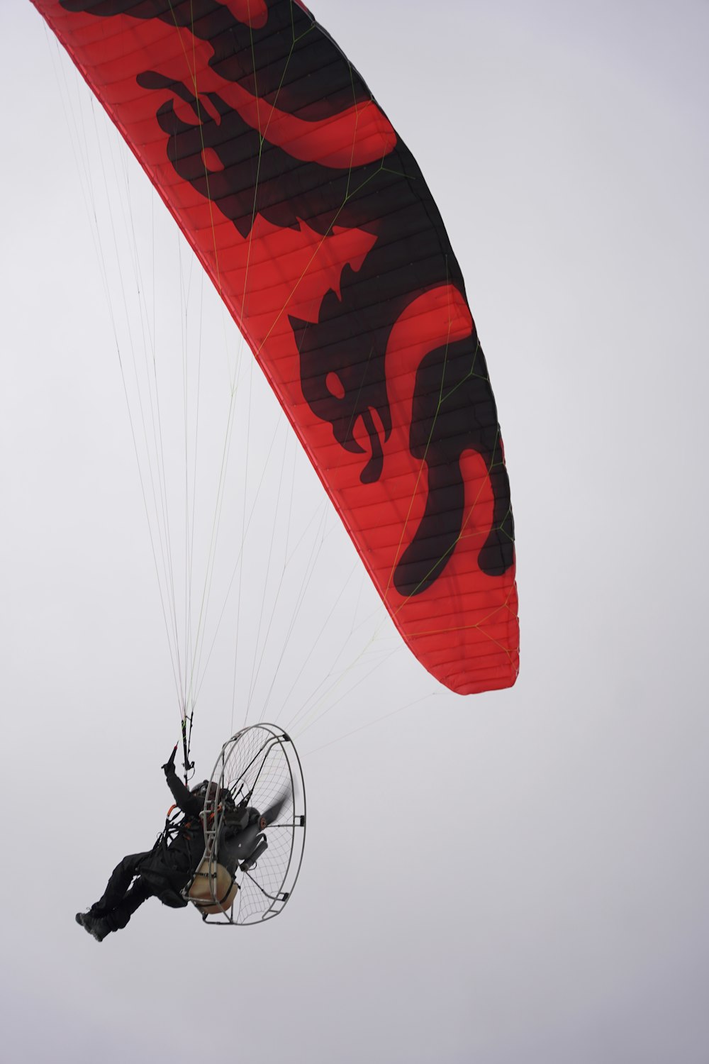 a man flying through the air while riding a parachute