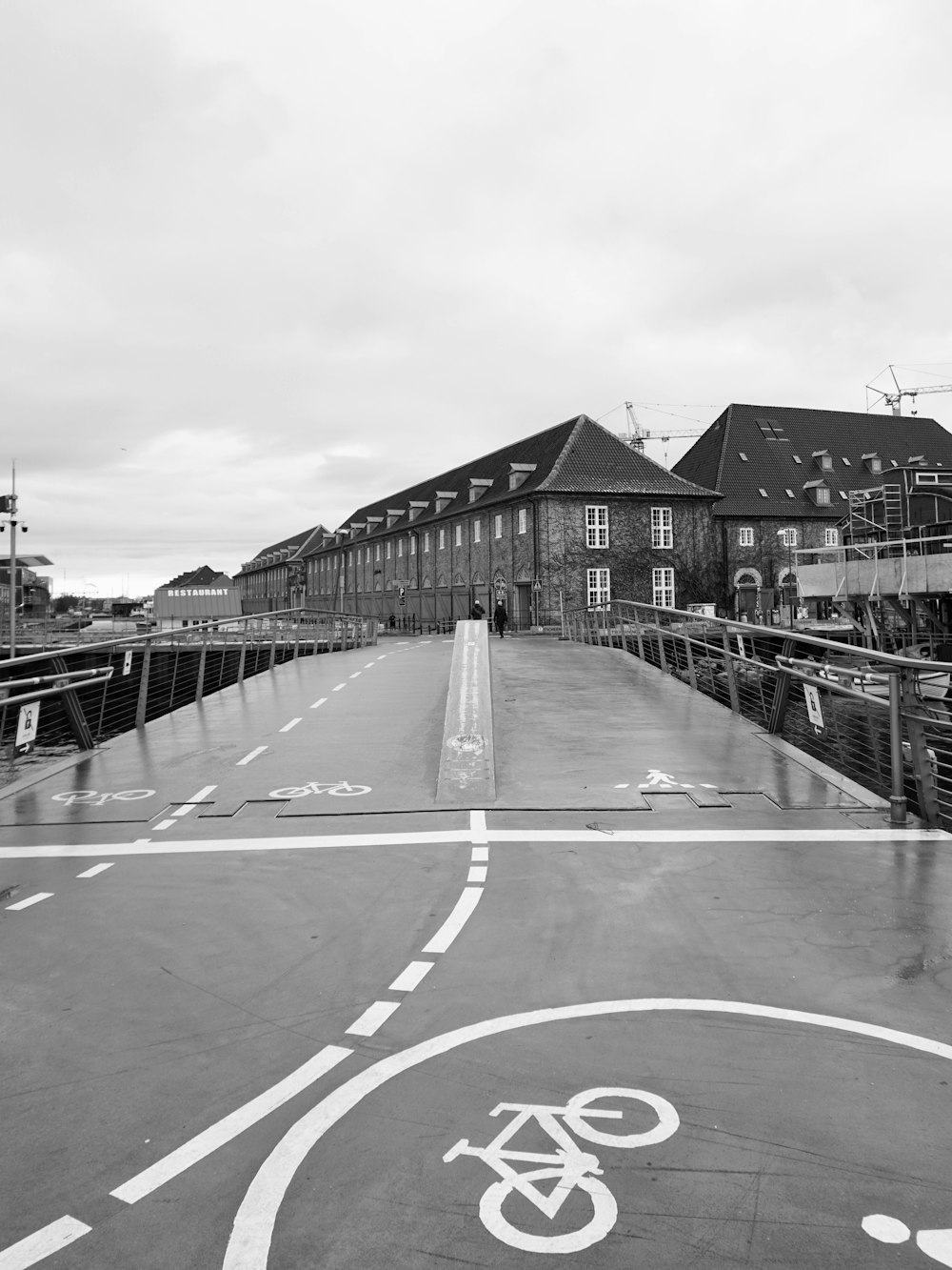 a bicycle lane on a bridge with buildings in the background