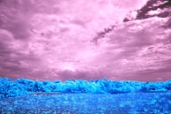 A landscape featuring a dramatic sky with deep blue tones and volumetric clouds, while the foreground remains untouched.