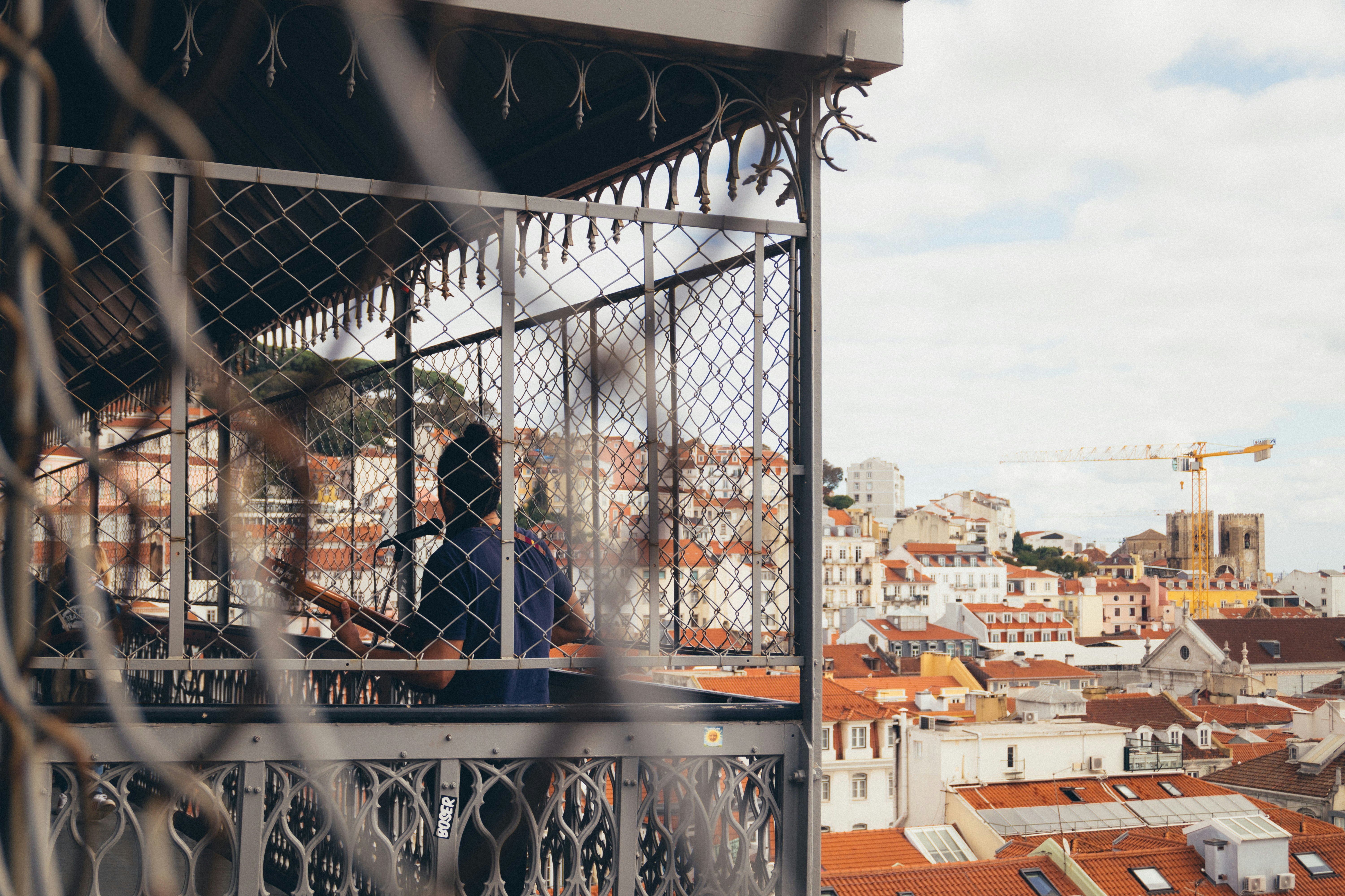 a man standing on top of a balcony next to a fence