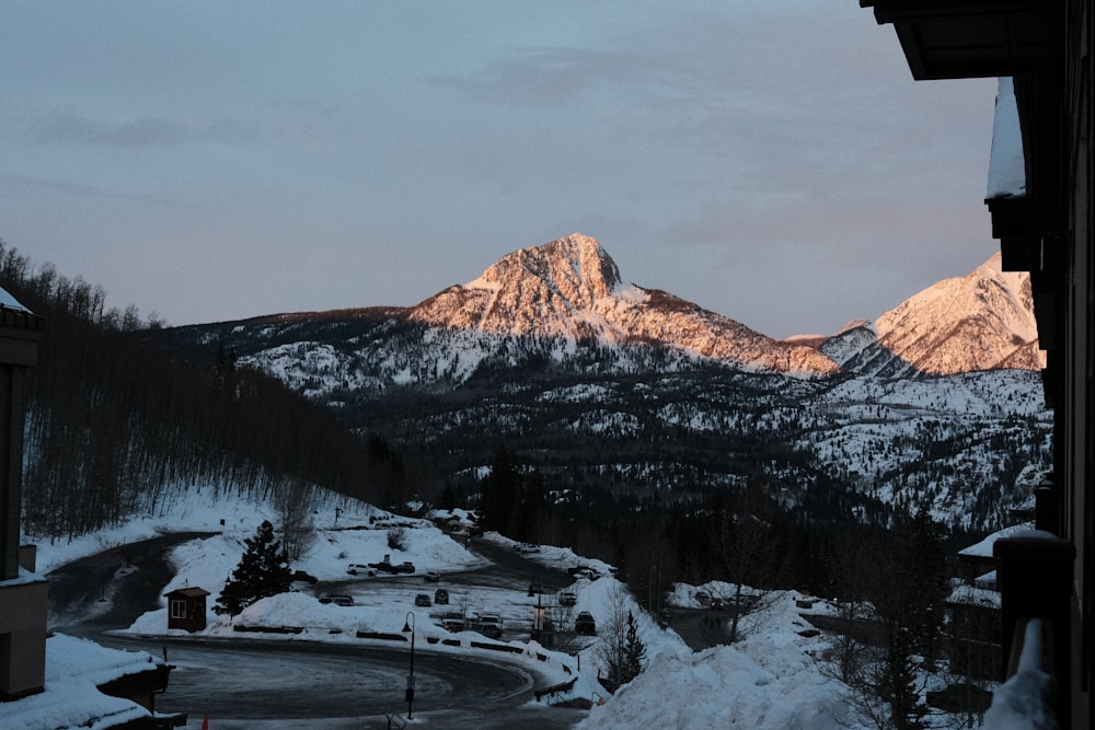 a view of a snowy mountain range from a balcony